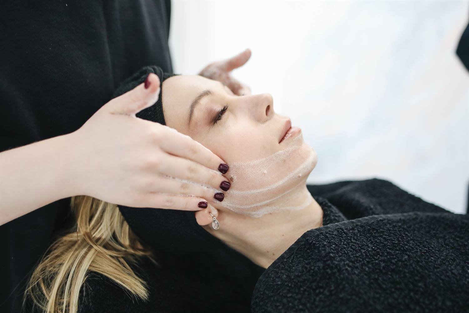 Tratamiento facial aplicado con cuidado en cabina de spa